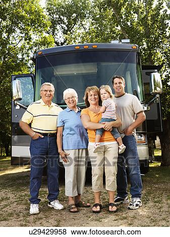Stock Photo - Portrait of three generation Caucasian family standing in front of recreational vehicle smiling and looking at viewer.. Fotosearch