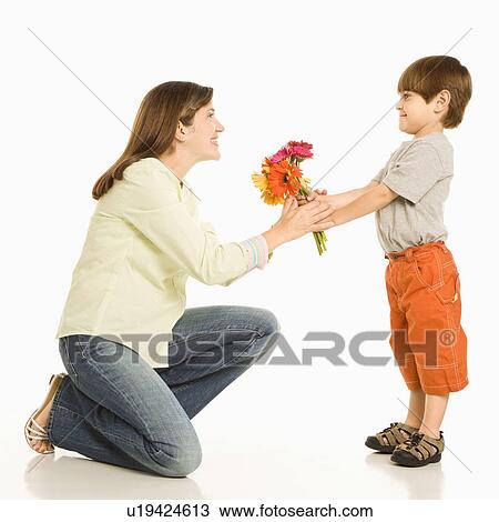 Stock Image - Son giving bouquet of flowers to mother. Fotosearch