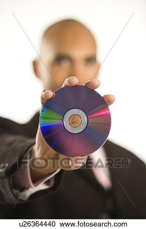 Stock Image - African American man holding out compact disc.. Fotosearch