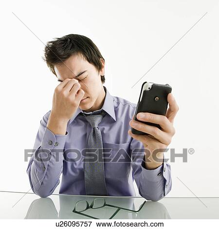 Asian businessman rubbing his tired eyes his pda cellphone. View Large Photo Image Stock Photo - Asian businessman rubbing his tired eyes his pda cellphone.. Fotosearch