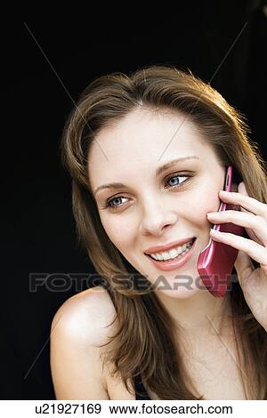 Stock Photo - Close up portrait of young adult female talking on cell phone and smiling.. Fotosearch