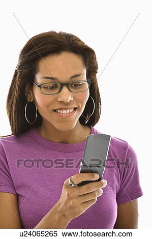 Stock Photography - Mid adult woman wearing glasses text messaging on cell phone. Fotosearch