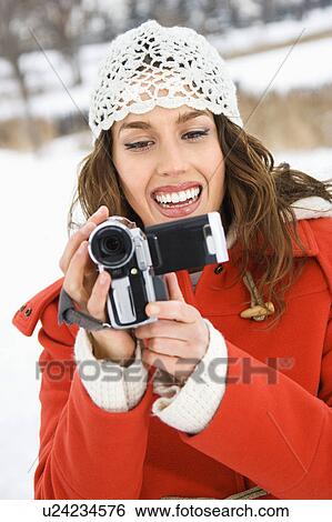 Smiling Caucasian young adult female in winter clothing pointing video camera at viewer. View Large Photo Image Stock Photograph - Smiling Caucasian young adult female in winter clothing pointing video camera at viewer.. Fotosearch