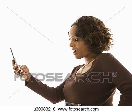 Stock Photo - Woman looking at cellphone with shocked expression. Fotosearch