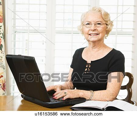 Stock Photograph - Woman using laptop in living room. Fotosearch
