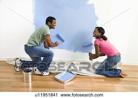 African American male and female couple painting wall blue. View Large Photo Image Stock Image - African American male and female couple painting wall blue.. Fotosearch