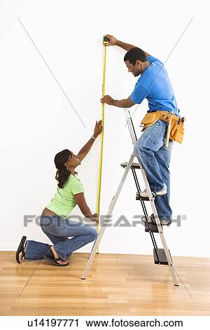 African American man and woman measuring wall at home. View Large Photo Image Stock Image - African American man and woman measuring wall at home.. Fotosearch