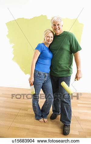Couple in front of wall they are painting green View Large Photo Image Picture - Couple in front of wall they are painting green. Fotosearch