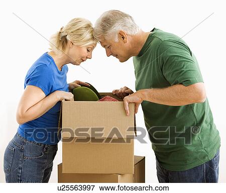 Stock Photo - Couple looking through cardboard box. Fotosearch