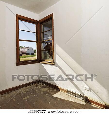 Empty abandoned room with sunrays stretching across wall from corner window View Large Photo Image Stock Photo - Empty abandoned room with sunrays stretching across wall from corner window. Fotosearch
