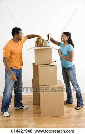 Male and female couple packing cardboard boxes with shoes View Large Photo Image Stock Photo - Male and female couple packing cardboard boxes with shoes. Fotosearch