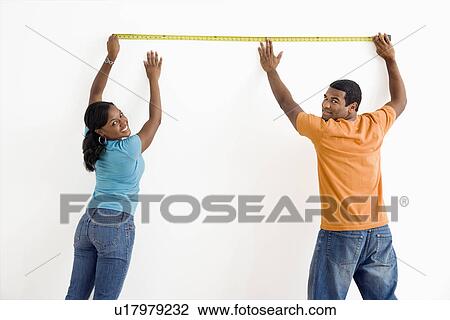 Male and female measuring wall View Large Photo Image Stock Image - Male and female measuring wall. Fotosearch