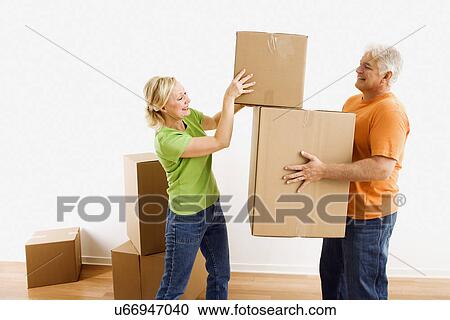 Man holding cardboard moving boxes while woman places one on stack View Large Photo Image Stock Image - Man holding cardboard moving boxes while woman places one on stack. Fotosearch