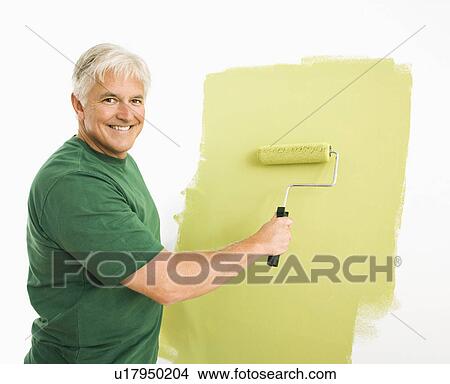 Man painting wall green with paint roller View Large Photo Image Picture - Man painting wall green with paint roller. Fotosearch