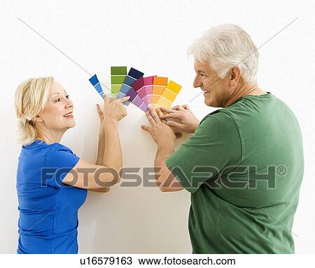 Middle-aged couple comparing and discussing paint swatches. View Large Photo Image Stock Image - Middle-aged couple comparing and discussing paint swatches.. Fotosearch
