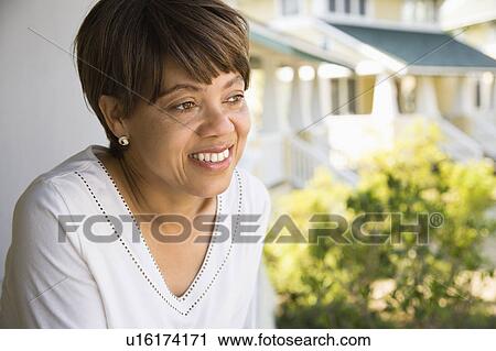 Woman outside home smiling View Large Photo Image Stock Image - Woman outside home smiling. Fotosearch