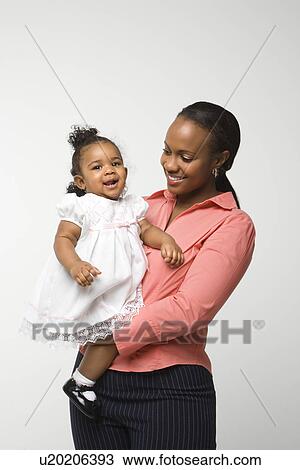 African American woman holding infant girl standing against white background. View Large Photo Image Stock Image - African American woman holding infant girl standing against white background.. Fotosearch