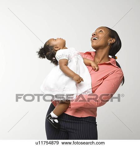African American woman holding infant girl standing against white background. View Large Photo Image Stock Photo - African American woman holding infant girl standing against white background.. Fotosearch