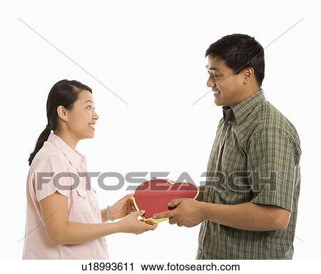 Asian man giving Asian woman a heart shaped box. Stock ...