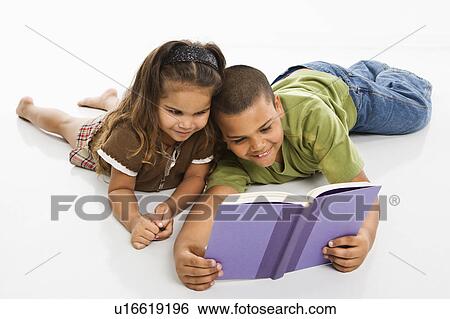 Stock Photograph - Brother and sister reading book together. Fotosearch