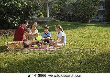 Caucasian family of four having picnic in park. View Large Photo Image Stock Photograph - Caucasian family of four having picnic in park.. Fotosearch