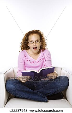 Caucasian female child sitting reading book looking surprised. View Large Photo Image Stock Photo - Caucasian female child sitting reading book looking surprised.. Fotosearch