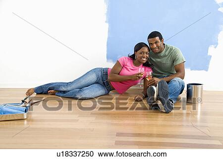 Couple relaxing together with wine next to half-painted wall and painting supplies View Large Photo Image Stock Image - Couple relaxing together with wine next to half-painted wall and painting supplies. Fotosearch