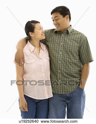 Stock Image - Couple standing with arms around each other. Fotosearch