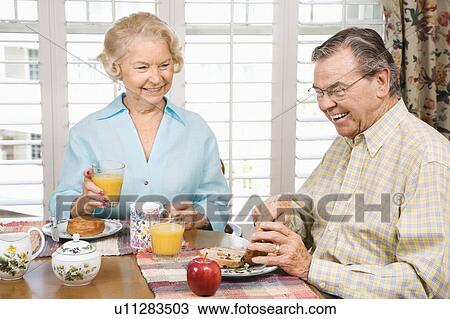 Stock Image - Mature couple having breakfast together. Fotosearch