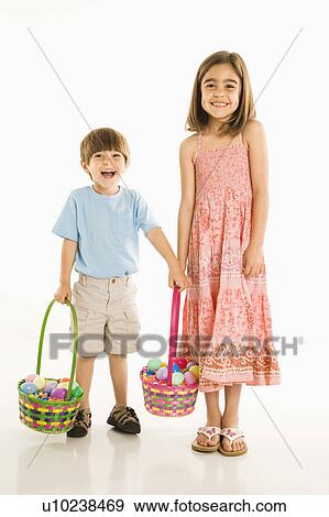 Smiling girl and boy standing with Easter baskets against white background. View Large Photo Image Stock Photo - Smiling girl and boy standing with Easter baskets against white background.. Fotosearch