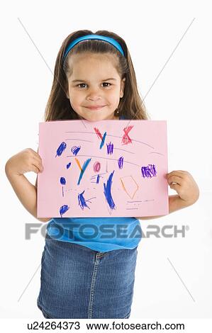 Stock Image - Smiling girl proudly holding drawing. Fotosearch