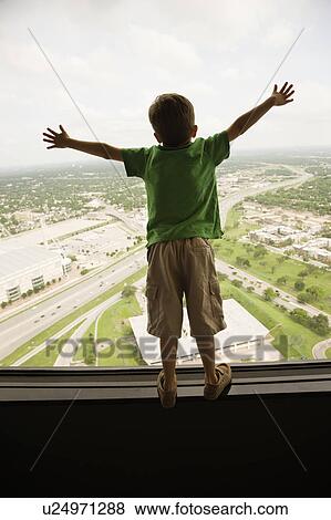 Stock Photo - Young Caucasian boy standing on observation deck at Tower of the Americas in San Antonio, Texas.. Fotosearch