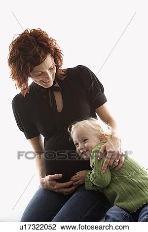 Young Caucasian female child with ear against her mother's pregnant belly. View Large Photo Image Stock Image - Young Caucasian female child with ear against her mother's pregnant belly.. Fotosearch