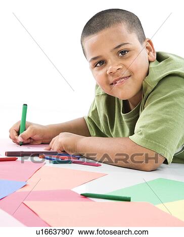 Stock Photo - Young latino boy coloring on construction paper.. Fotosearch