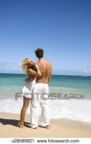 Attractive couple standing on Maui, Hawaii beach holding eachother. View Large Photo Image Stock Image - Attractive couple standing on Maui, Hawaii beach holding eachother.. Fotosearch