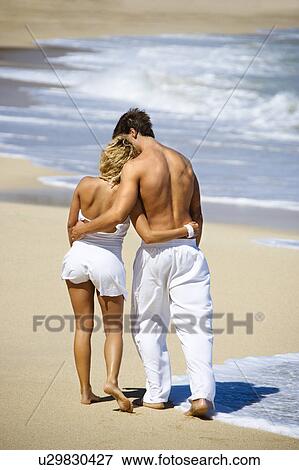 Attractive couple walking on Maui, Hawaii beach with arms around eachother. View Large Photo Image Stock Photo - Attractive couple walking on Maui, Hawaii beach with arms around eachother.. Fotosearch