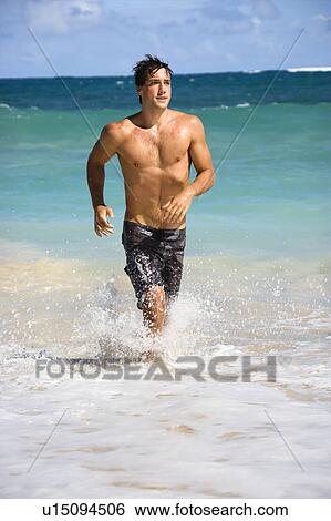 Attractive man running in water on Maui, Hawaii beach. View Large Photo Image Stock Photograph - Attractive man running in water on Maui, Hawaii beach.. Fotosearch