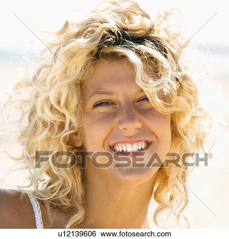 Stock Photograph - Close up portrait of pretty young blond woman smiling.. Fotosearch