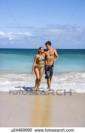 Couple embracing and smiling as they walk out of water in Maui, Hawaii View Large Photo Image Stock Image - Couple embracing and smiling as they walk out of water in Maui, Hawaii. Fotosearch