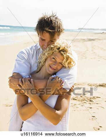 Picture - Couple embracing on beach. Fotosearch