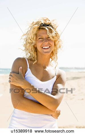 Stock Photo - Portrait of pretty young blond woman smiling on Maui, Hawaii beach. Fotosearch