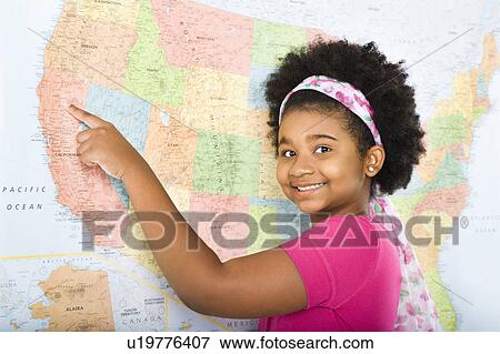Stock Photo - African American girl pointing to map of United States and smiling at viewer.. Fotosearch