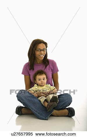 African American mid adult mom sitting with toddler son on lap looking at viewer. View Large Photo Image Stock Photography - African American mid adult mom sitting with toddler son on lap looking at viewer.. Fotosearch