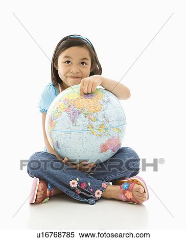 Stock Photography - Asian girl sitting on floor holding Earth globe in her lap.. Fotosearch