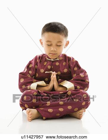 Boy sitting meditating against white background in traditional attire. View Large Photo Image Stock Photo - Boy sitting meditating against white background in traditional attire.. Fotosearch