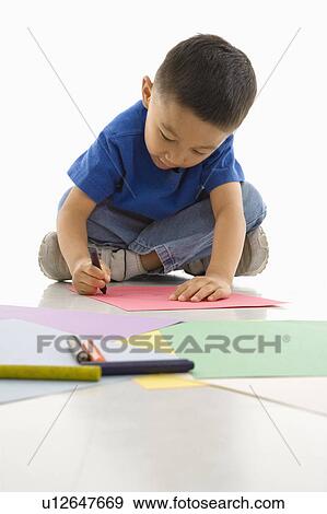 Boy sitting on floor coloring on paper View Large Photo Image Stock Photo - Boy sitting on floor coloring on paper. Fotosearch