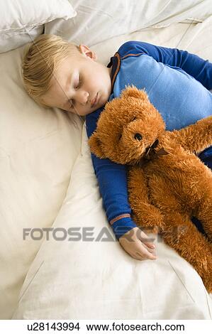 Caucasian toddler boy sleeping in bed with teddy bear. View Large Photo Image Picture - Caucasian toddler boy sleeping in bed with teddy bear.. Fotosearch