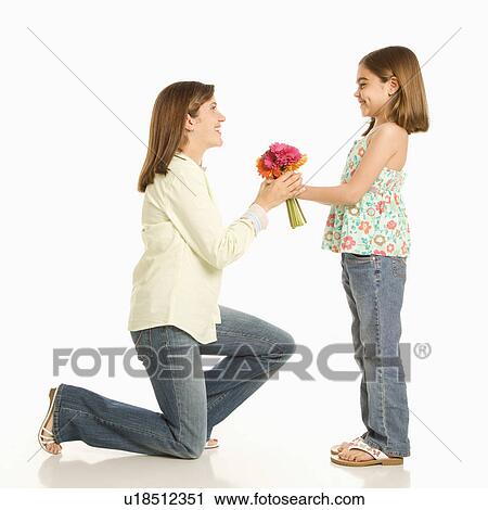Stock Image - Daughter giving bouquet of flowers to mother.. Fotosearch