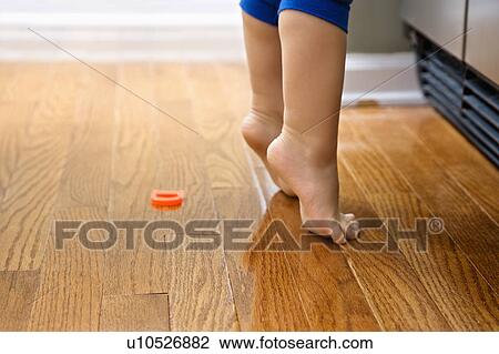 Stock Image - Feet of toddler boy with magnets in front of refrigerator.. Fotosearch