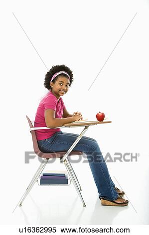 Girl sitting in school desk smiling View Large Photo Image Stock Photography - Girl sitting in school desk smiling . Fotosearch